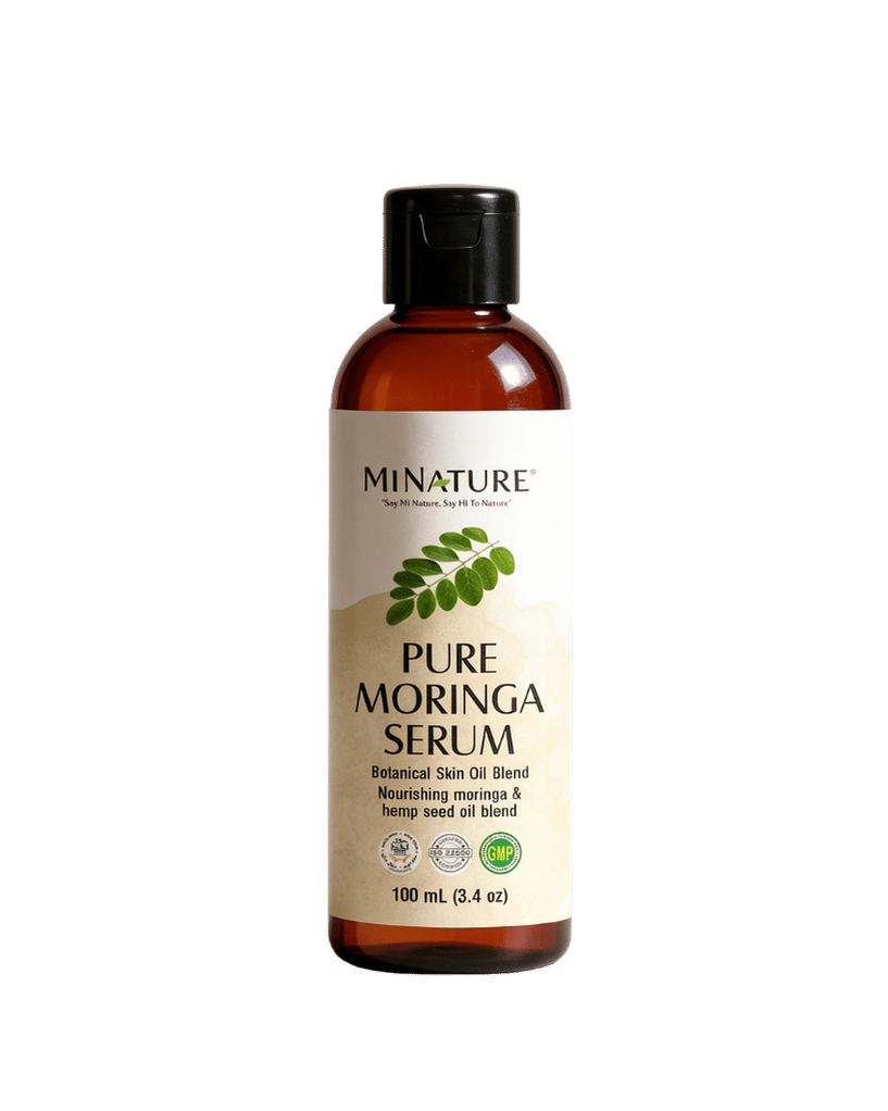 A 100 mL bottle of MiNature Pure Moringa Serum, featuring an amber glass bottle, a black flip-top cap, and a cream-colored label with green leaf graphics.